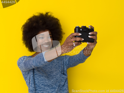 Image of young african american girl taking photo on a retro camera