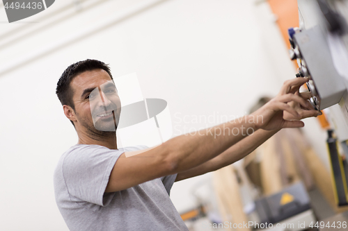 Image of worker in a factory of wooden furniture