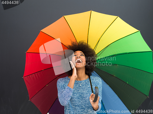 Image of african american woman holding a colorful umbrella
