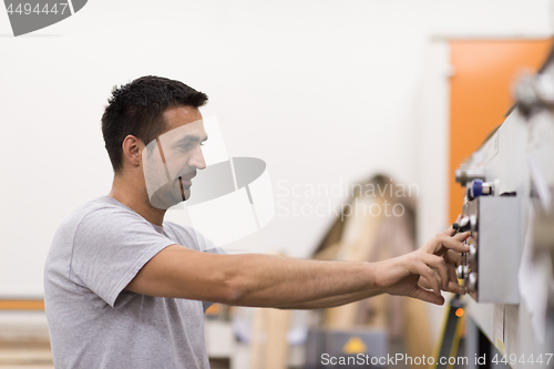 Image of worker in a factory of wooden furniture