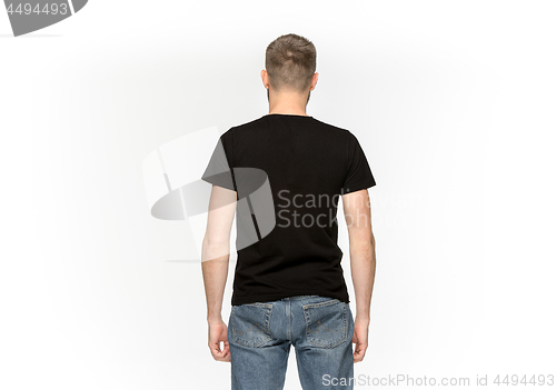 Image of Closeup of young man\'s body in empty black t-shirt isolated on white background. Mock up for disign concept