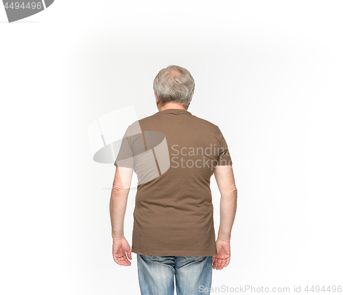 Image of Closeup of senior man\'s body in empty brown t-shirt isolated on white background. Mock up for disign concept