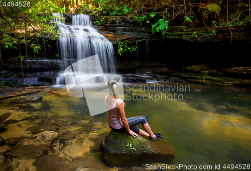 Image of Woman at waterfall and swimming hole in bushland wilderness