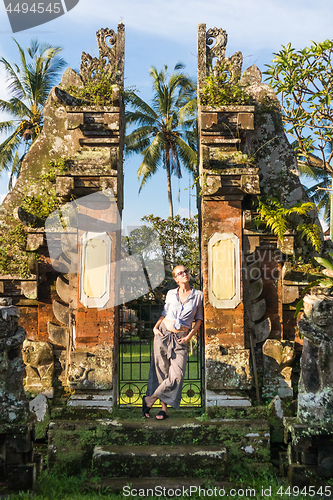 Image of Young blonde caucasian woman traveling and exploring traditional hidu tamples around Ubud on Bali.