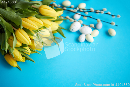 Image of Holiday contept decoration with easter eggs and yellow tulips ov