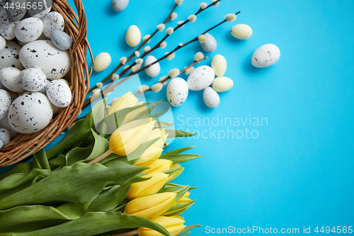 Image of Holiday contept decoration with easter eggs and yellow tulips ov