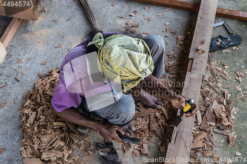 Image of Carpenter working in traditional manual carpentry shop in a third world country.