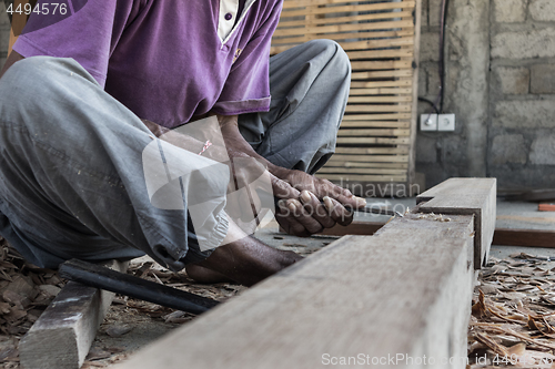 Image of Close up of warn hands of carpenter working in traditional manual carpentry shop in a third world country.