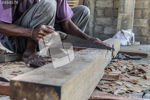 Image of Close up of warn hands of carpenter working in traditional manual carpentry shop in a third world country.