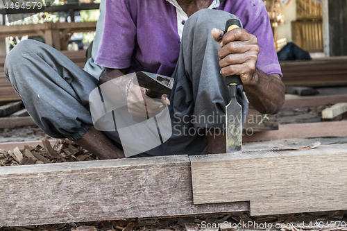 Image of Close up of warn hands of carpenter working in traditional manual carpentry shop in a third world country.