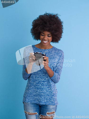 Image of african american girl taking photo on a retro camera