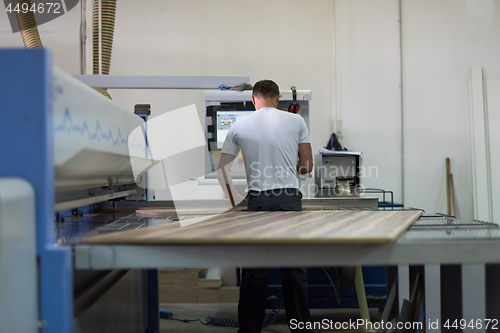 Image of worker in a factory of wooden furniture