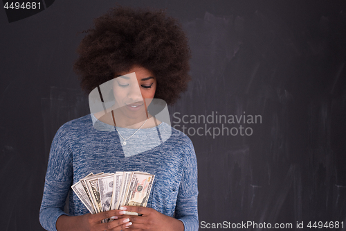 Image of black woman holding money on gray background