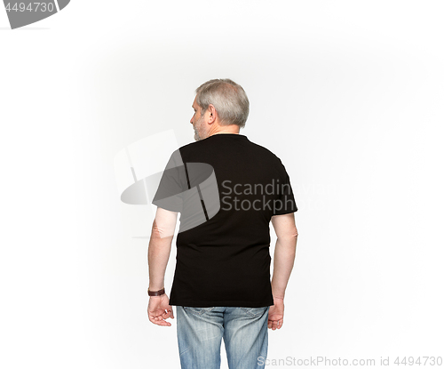 Image of Closeup of senior man\'s body in empty black t-shirt isolated on white background. Mock up for disign concept