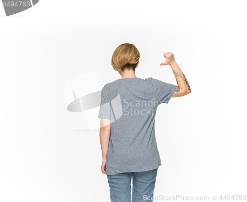 Image of Closeup of young woman\'s body in empty gray t-shirt isolated on white background. Mock up for disign concept