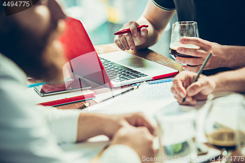 Image of The hands of people working and relaxing in pub.