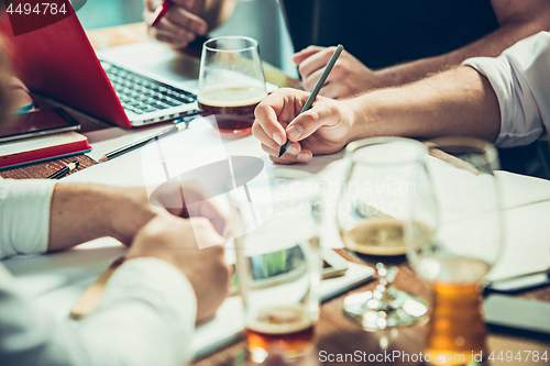 Image of The hands of people working and relaxing in pub.