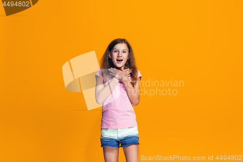 Image of Beautiful teen girl looking suprised isolated on orange