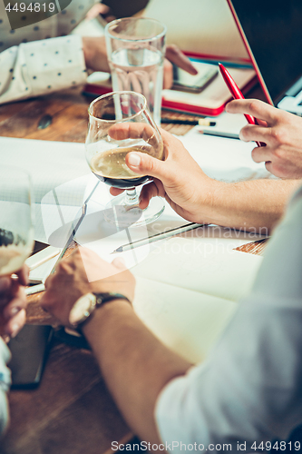 Image of The hands of people working and relaxing in pub.