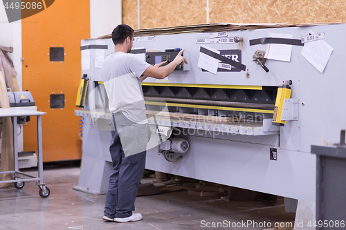 Image of worker in a factory of wooden furniture