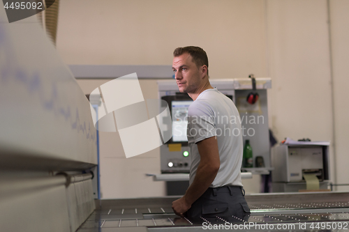 Image of worker in a factory of wooden furniture