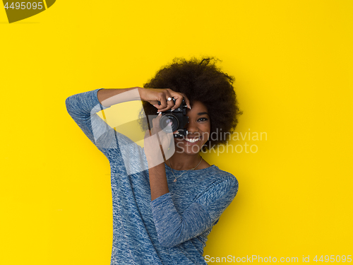 Image of young african american girl taking photo on a retro camera