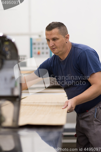 Image of worker in a factory of wooden furniture