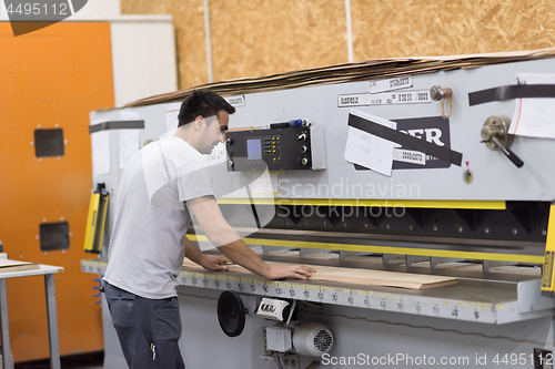 Image of worker in a factory of wooden furniture