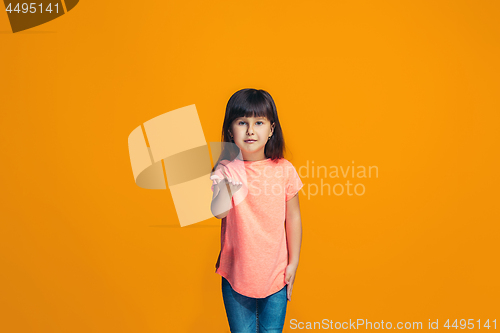 Image of The happy teen girl standing and smiling against orange background.