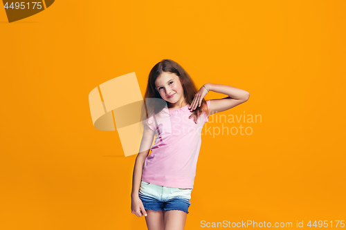 Image of Beautiful teen girl looking suprised isolated on orange