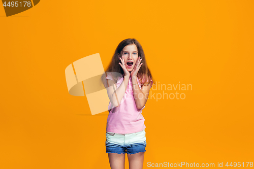 Image of Beautiful teen girl looking suprised isolated on orange