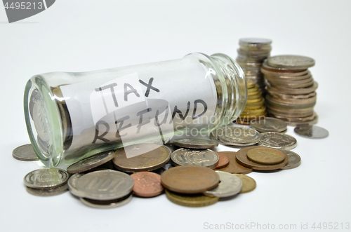 Image of Tax refund lable in a glass jar with coins spilling out