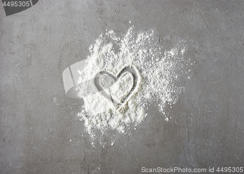 Image of heart shape in flour on grey kitchen table