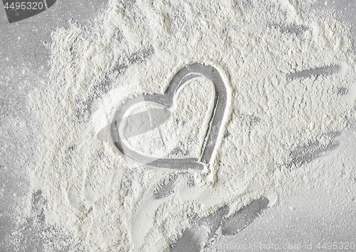 Image of heart shape in flour on grey kitchen table