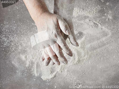 Image of baker hands with flour in motion