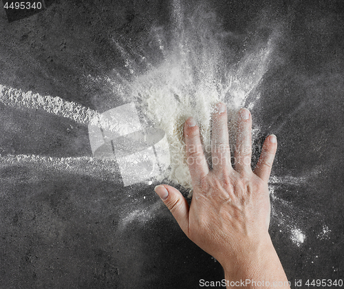 Image of bakers hand with flour in motion