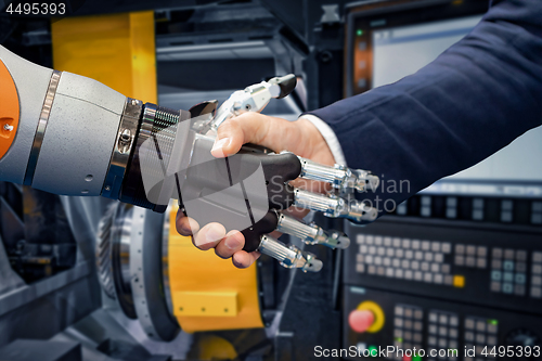 Image of Hand of a businessman shaking hands with a Android robot.