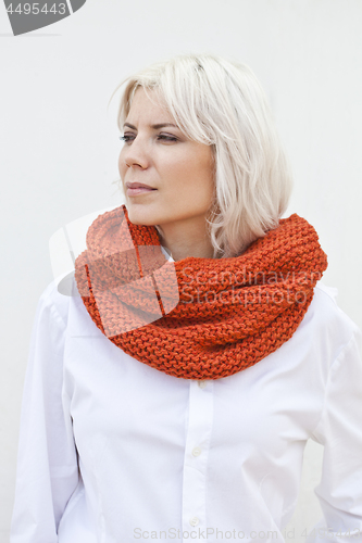 Image of Woman in warm orange wool knitted snood scarf.