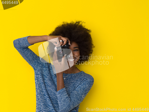 Image of young african american girl taking photo on a retro camera