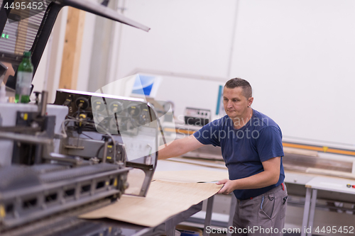 Image of worker in a factory of wooden furniture