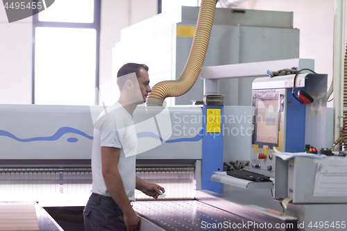 Image of worker in a factory of wooden furniture