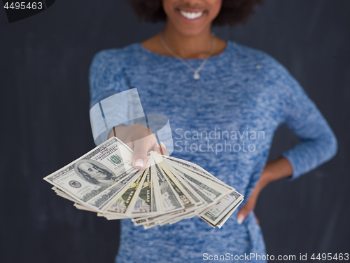 Image of black woman holding money on gray background