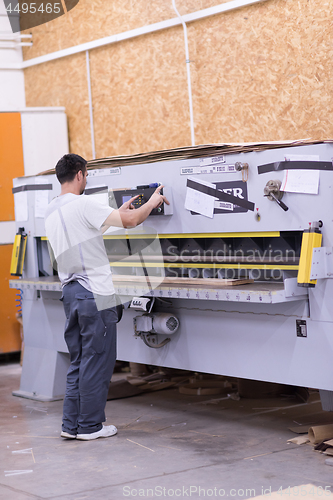 Image of worker in a factory of wooden furniture