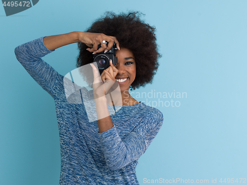 Image of african american girl taking photo on a retro camera