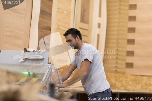 Image of worker in a factory of wooden furniture