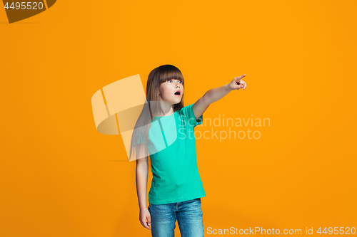 Image of Beautiful teen girl looking suprised isolated on orange