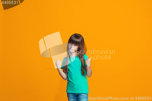 Image of Portrait of angry teen girl on a orange studio background