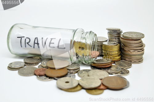 Image of Travel lable in a glass jar with coins spilling out