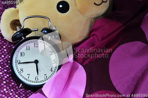 Image of Retro alarm clock and brown teddy bear