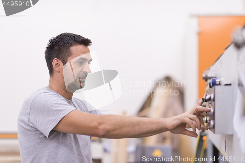 Image of worker in a factory of wooden furniture